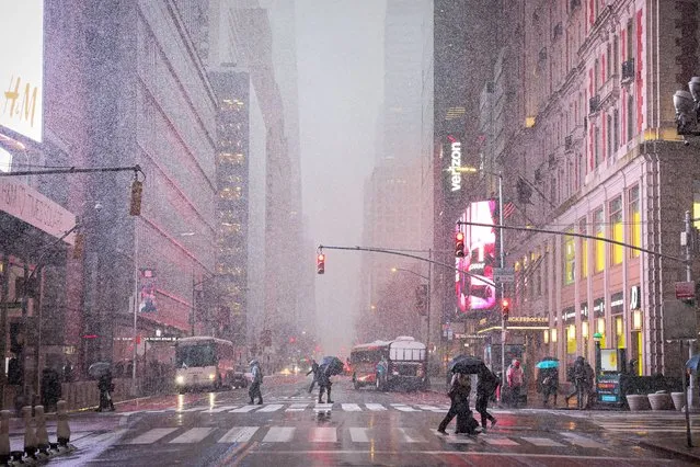 Morning commuters make their way through wind and snow during a Nor'easter winter storm in Times Square in New York City, U.S., February 13, 2024. (Photo by Brendan McDermid/Reuters)