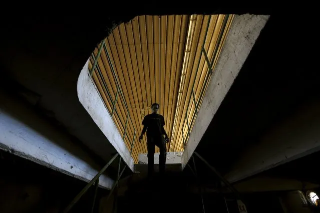 Sudanese immigrant Mahdi Babika Mohamed, who is also a rap singer with the stage name Twopack, walks down stairs at his shelter in the western Greek town of Patras May 4, 2015. (Photo by Yannis Behrakis/Reuters)