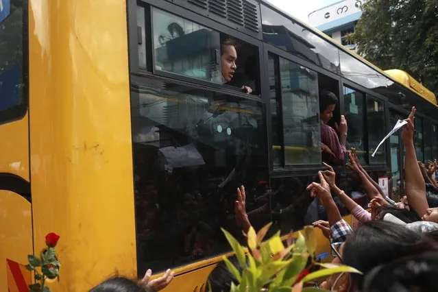 Detainees shout from a bus after a mass-prisoner release from the Insein Prison Tuesday, October 19, 2021, in Yangon, Myanmar. (Photo by AP Photo/Stringer)