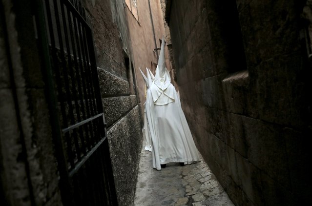 Penitents of the “La Merced” brotherhood walk through a narrow street before taking part in a Palm Sunday procession at the start of Holy Week in Palma de Mallorca, on the Spanish Balearic island of Mallorca, March 20, 2016. (Photo by Enrique Calvo/Reuters)