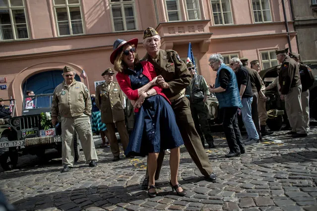 History enthusiasts dressed in US Army uniforms from World War II dance during the “Convoy of Liberty” in Prague, Czech Republic, 26 April 2019. The 'Convoy of Liberty' commemorates the liberation of the western part of Czech Republic from Nazi oppression by the US Army at the end of the World War II in April and May 1945. The convoy's route begins on the bank of Vltava river in Prague and traditionally makes its first stop in front of the US Embassy, where it is welcomed by a Czech Army Military Band and many spectators. (Photo by Martin Divíšek/EPA/EFE)