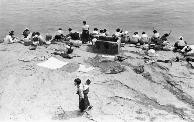 “Though struggling with the multifaceted after-effects of the Korean war, the 1950s was a period of recovery. I was able to find hope watching cities and rural communities being rebuilt; in the bustling markets and the sparkling eyes of children, the laughter I had forgotten. Slowly but steadily I was recovering my own humanity”. Here: Hangang River, Seoul, Korea. (Photo by Han Youngsoo/The Guardian)