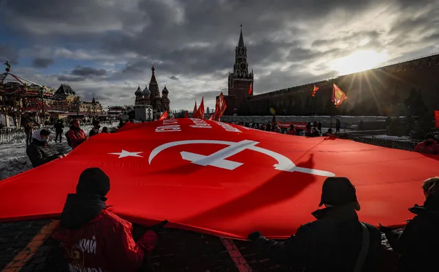 Communist party members and supporters hold a huge replica of the Victory banner at the Red Square in Moscow, Russia, 04 December 2021. Russian communists gather to mark the 80th anniversary of the decisive Soviet counteroffensive near Moscow during World War II. (Photo by Yuri Kochetkov/EPA/EFE)