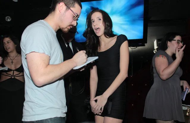 Belle Knox, ctr.,  a Duke University student who acts in p*rn to pay for her education, talks to a reporter at Headquarters, a strip bar, in Manhattan, Tuesday, March 18, 2014. (Photo by Robert Mecea)