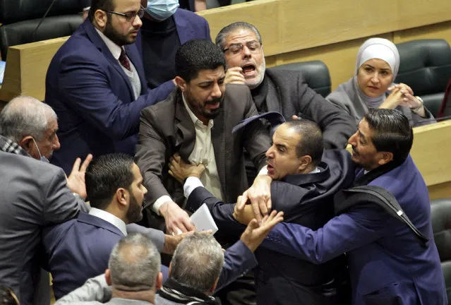 Jordanian parliament members are separated during an altercation in the parliament in the capital Amman on December 28, 2021. (Photo by AFP Photo/Stringer Network)