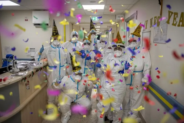 Healthcare workers in personal protective equipment (PPE) celebrate the new year in the Intensive Care Unit (ICU) on New Year's Eve in the COVID-19 department of the San Filippo Neri Hospital amid the coronavirus pandemic, on December 31, 2020, in Rome, Italy. Hospitals in Italy are under pressure as they battle to treat those who have contracted COVID-19 in final days of 2020. The Italian government continues to enforce national lockdown measures to control the spread of COVID-19. There have been over 2,070,000 reported coronavirus (COVID-19) cases in Italy and more than 73,029 related deaths since the beginning of the pandemic. (Photo by Antonio Masiello/Getty Images)