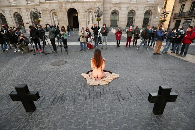 A naked animal rights activist performs during a protest against the use of fur and leather, at Sant Jaume Square in Barcelona, Spain on January 21, 2021. (Photo by Albert Gea/Reuters)