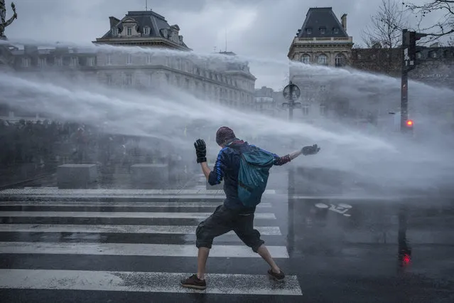 A truck-mounted water cannon sprays a protester during a demonstration against the Global Security Bill on January 30, 2021 at the Place de la République in Paris, France. France's lawmakers passed and adopted the bill known as article 24 of the “comprehensive security” law prohibiting the dissemination of images of the police, alarming journalists and activists saying civil liberties and press freedom could be compromised. Several MPs have criticised the bill's implications and President Macron has come under fire from national journalism unions and the UN for the law and police accountability. (Photo by Kiran Ridley/Getty Images)