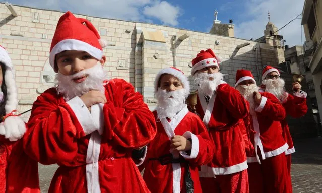Palestinian Christian children dressed as Santa Claus, walk outside the Church of Saint Porphyrios during Christmas celebrations in Gaza City, on December 24, 2021. (Photo by APAImages/Rex Features/Shutterstock)