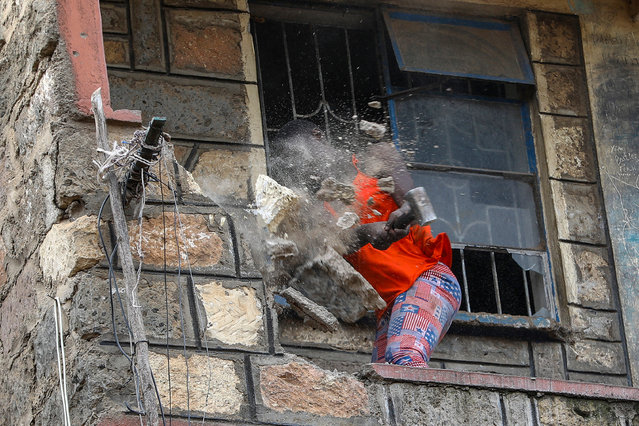 A woman hammers a balcony as she scavenges for scrap metal from buildings demolished by multi-state security agencies in Mathare North, Nairobi, Kenya, 09 May 2024. Kenyan security agencies continue to demolish houses near the riverbanks of Nairobi, which were affected during continuous floods that have caused havoc in the country. Kenyan President William Ruto ordered the agencies to evacuate everyone living close to 178 mapped out dams that are said to be full, riverbanks, and areas prone to mudslides following continued heavy rainfall which has so far killed more than 200 people since March. (Photo by Daniel Irungu/EPA/EFE)