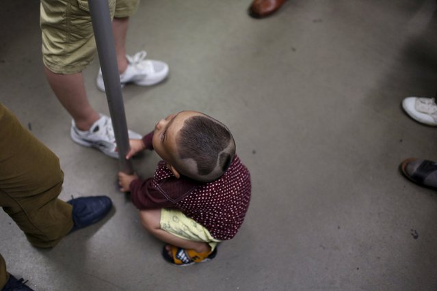 A 3-year-old boy is pictured with an Apple logo haircut on a subway in Shanghai, China, June 27, 2015. (Photo by Aly Song/Reuters)