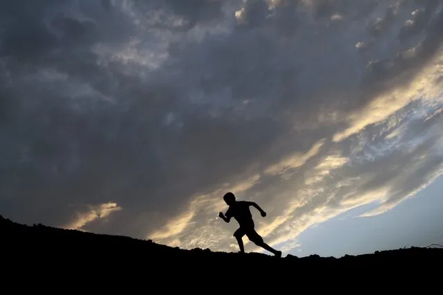 A child runs on a hill as the sun sets in Managua May 19, 2015. (Photo by Oswaldo Rivas/Reuters)