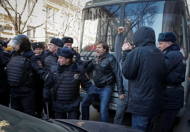 An opposition supporter (C) blocks a police van transporting detained anti-corruption campaigner and opposition figure Alexei Navalny during a rally in Moscow, Russia, Sunday, March 26, 2017. (Photo by Maxim Shemetov/Reuters)