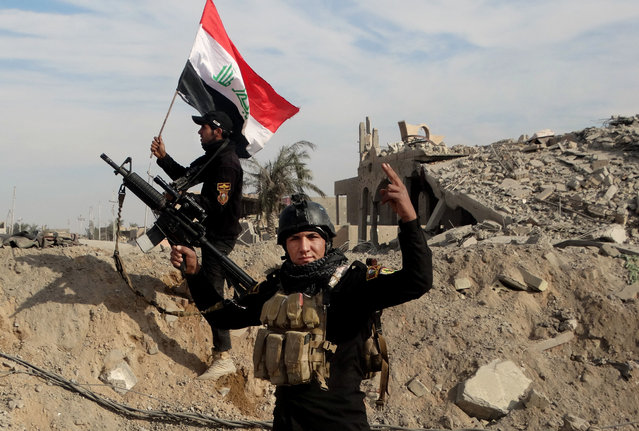 Iraqi counterterrorism soldiers raise an Iraqi flag on the ruins of a building near the provincial council headquarters in Ramadi in this December 27, 2015 file photo, during the offensive that freed the Iraqi city from nearly a year of rule by the Islamic State group. Satellite photos show the price that months of fighting wreaked on the city: More than 3,000 buildings and nearly 400 roads and bridges damaged or destroyed, with whole city blocks wiped out in some cases, from airstrikes, fighting or intentional destruction by the militants. (Photo by Osama Sami/AP Photo)