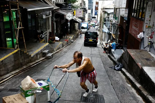 A man pushes a cart up a street in the Sheung Wan neighbourhood in Hong Kong, China, August 19, 2019. (Photo by Thomas Peter/Reuters)