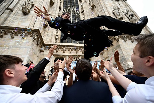 A newly ordered Catholic priest celebrates with friends and relatives outside the Duomo Cathedral, in Milan, after the ordination ceremony on June 10, 2023. (Photo by Gabriel Bouys/AFP Photo)