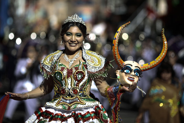 A woman holding a mask costume dances Diablada during Lord Of The Great Power festivity parade on May 25, 2024 in La Paz, Bolivia. This parade, which has been held in La Paz since 1930, mixes Catholicism and local traditions and folklore from the Andean region. (Photo by Gaston Brito/Getty Images)