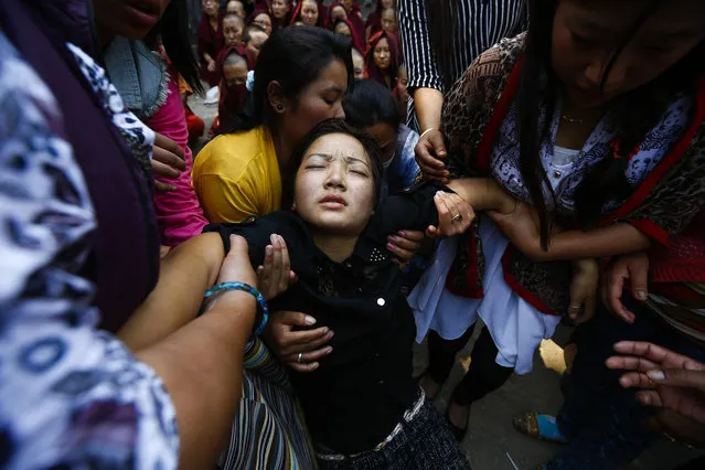 Daughter of Ang Kaji Sherpa, one of the victims of the Mount Everest avalanche on April 18, collapses during a cremation ceremony at Syambhu in Kathmandu, Nepal, April 21, 2014. The single deadliest accident in the history of the world's highest mountain took the lives of 16 Sherpas on 18 April 2014, leaving the Everest climbing community in a state of shock. (Photo by Narendra Shrestha/EPA)