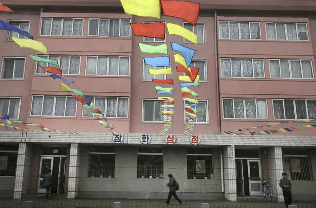 A woman walks past a store where the streets in front of it is decorated with flags on Friday, May 6, 2016, in Pyongyang, North Korea. (Photo by Wong Maye-E/AP Photo)