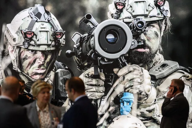 Delegates socialise in front of a large display on the SAAB stand on day two of the DSEI arms fair at ExCel on September 11, 2019 in London, England. The biennial Defence and Security Equipment International (DSEI) is the world's largest arms fair and is held in London's Docklands area. (Photo by Leon Neal/Getty Images)
