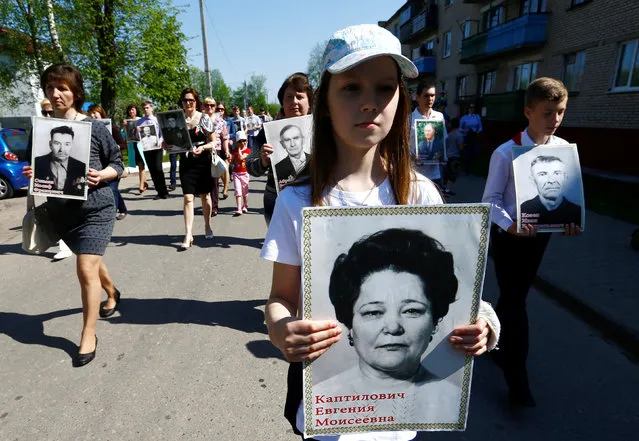 People carry pictures of World War Two participants as they take part in the Memory march during the Victory Day celebrations, marking the 71st anniversary of the victory over Nazi Germany in World War Two, in the town of Dyatlovo, Belarus May 9, 2016. (Photo by Vasily Fedosenko/Reuters)