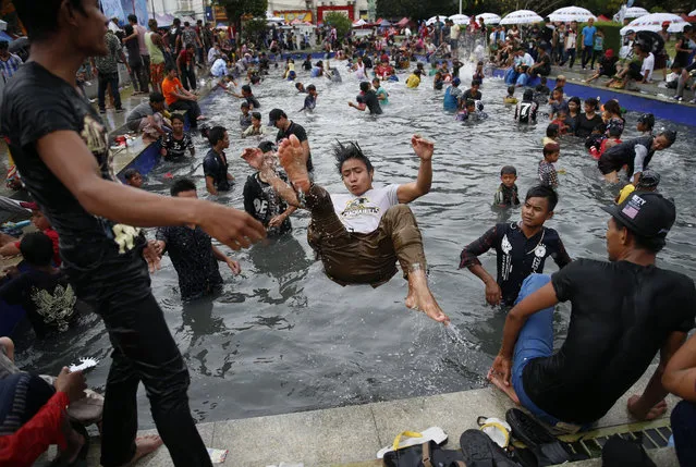 Myanmar people enjoy Thingyan water festival in Yangon, Myanmar, 14 April 2017. The annual water festival is celebrated with large groups of people congregating to celebrate by splashing water and throwing powder at each others faces as a symbolic sign of cleansing and washing away the sins from the old year to mark the traditional New Year in countries such as Myanmar, Thailand, Laos and Cambodia. This year Myanmar Thingyan water festival falls on 13 April and ends on 16 April. (Photo by Lynn Bo Bo/EPA)