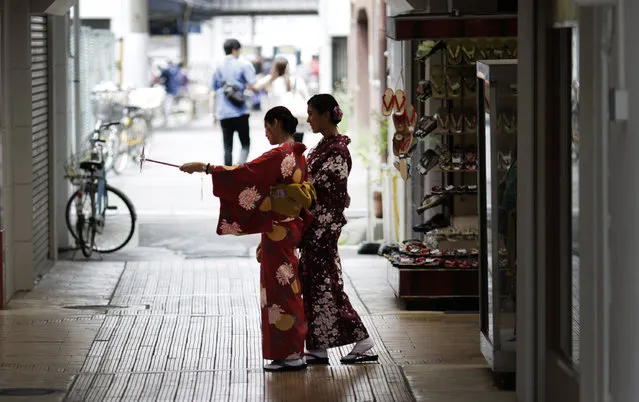 Tourists wearing traditional Japanese kimonos use a selfie stick to take a photo of themselves in the Asakusa district in Tokyo Wednesday, May 6, 2015. Asakusa is an old town in the capital that draws many tourists from across the world. (Photo by Eugene Hoshiko/AP Photo)
