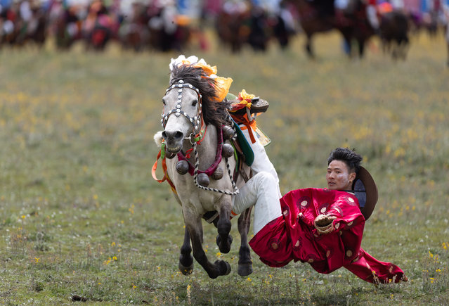 A rider demonstrates his skills at a racecourse in Litang County, the Tibetan Autonomous Prefecture of Garze, southwest China's Sichuan Province, July 30, 2024. A horse racing event kicked off in Litang County on Tuesday, attracting nearly 1,000 herdsmen from across the county to participate in a variety of activities. (Photo by Xinhua News Agency/Rex Features/Shutterstock)