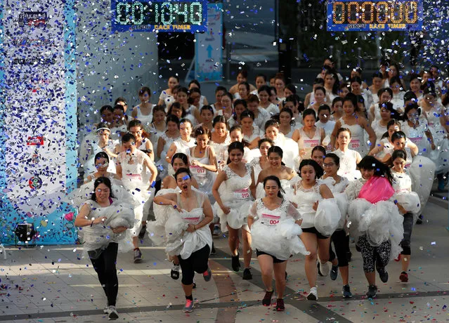 Thai brides-to-be wearing bridal gowns compete in the “Running of the Brides” event in Bangkok, Thailand, 24 November 2019. One hundred fifty couples of to be brides and their grooms compete in a three kilometers run race and challenge in seven tasks aimed to win a wedding package prizes including a pair of diamond rings and honeymoon trip to the Maldives. (Photo by Rungroj Yongrit/EPA/EFE)