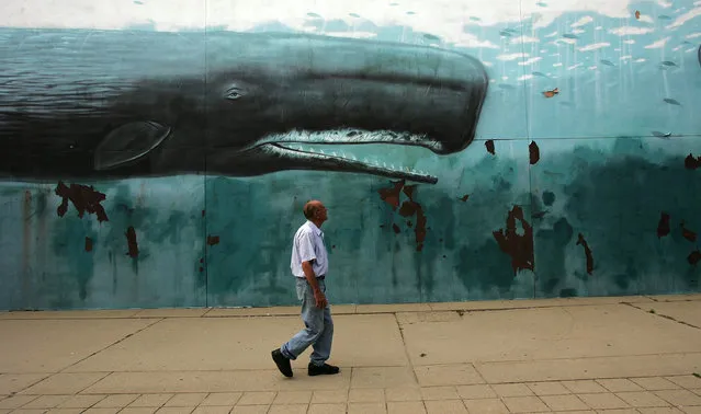 A man walks past a mural June 27, 2005 in downtown New London, Connecticut. (Photo by Spencer Platt/Getty Images)