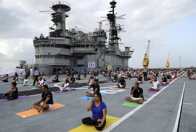Indian armed forces and their families members perform Yoga on the deck of the Indian Naval aircraft carrier Viraat to mark International Yoga Day in Mumbai, India, Wednesday, June 21, 2017. Yoga practitioners took a relaxing break to bend, twist and pose Wednesday morning for the annual event celebrating the practice, especially in the country where it began. (Photo by Rajanish Kakade/AP Photo)