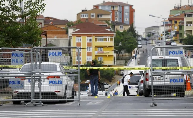 Plainclothes police officers and forensic experts examine the scene after an attack on a police station in Istanbul, Turkey, August 10, 2015. Overnight, a vehicle laden with explosives was used in the attack on the police station in the Istanbul district of Sultanbeyli at around 01:00 on Monday (22:00GMT on Sunday), injuring three police officers and seven civilians, police said. (Photo by Huseyin Aldemir/Reuters)