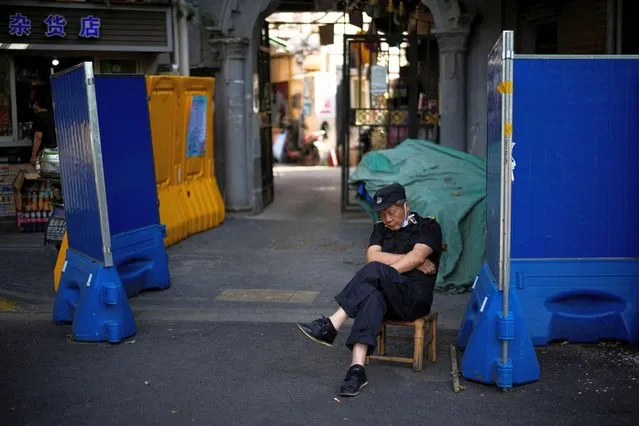 A security guard takes a nap in a residential area, after the lockdown placed to curb the coronavirus disease (COVID-19) outbreak was lifted in Shanghai, China on June 7, 2022. (Photo by Aly Song/Reuters)