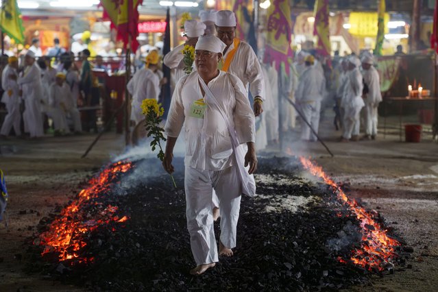 Malaysian Chinese devotees walk barefoot over burning coals during the Nine Emperor Gods festival at a temple in Kuala Lumpur, Malaysia, Friday, October 11, 2024. (Photo by Vincent Thian/AP Photo)