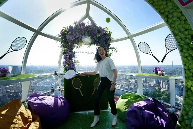 A visitor hits a tennis ball on Wednesday, June 22, 2022 inside a pod on the lastminute.com London Eye which has been deocarted with a Wimbledon theme ahead of the start of tennis competition next week. (Photo by Victoria Jones/PA Images via Getty Images)