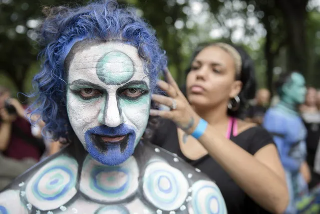 Cully Firmin, of Lafayette, La., is painted at Columbus Circle as body-painting artists gathered to decorate nude models as part of an event featuring artist Andy Golub, Saturday, July 26, 2014, in New York. Golub says New York was the only city in the country that would allow his inaugural Bodypainting Day. (Photo by John Minchillo/AP Photo)