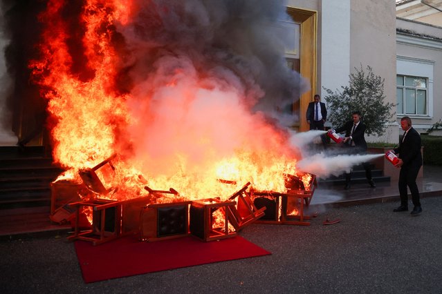 Members of National Guard use extinguishers as members of the opposition burn their chairs outside the parliament building, to protest against the government and the imprisonment of their colleague Ervin Salianji, in Tirana, Albania, on September 30, 2024. (Photo by Florion Goga/Reuters)