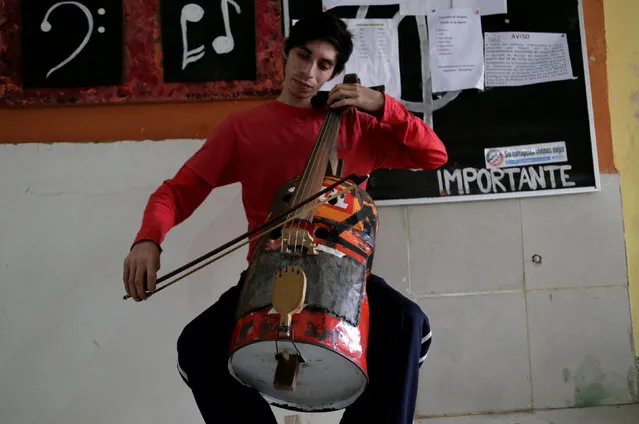 A musician from the Orchestra of Recycled Instruments of Cateura plays a cello made from a recycled oil barrel in Cateura, near Asuncion, Paraguay, August 14, 2017. (Photo by Jorge Adorno/Reuters)