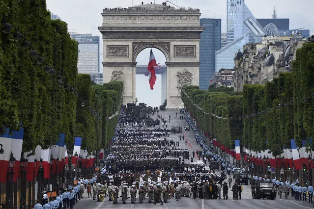 Troops wait near the Arc de Triomphe, in Paris, before taking part in the annual Bastille Day military parade on the Champs-Elysees avenue on July 14, 2016. (Photo by Dominique Faget/AFP Photo)