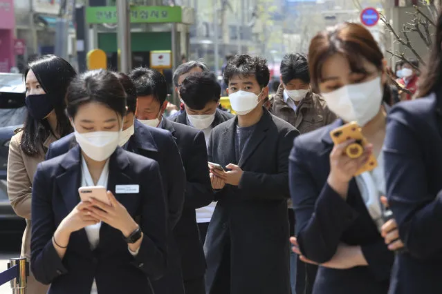 People wearing face masks to help protect against the spread of the new coronavirus wait to cast their early votes for the upcoming parliamentary election at a polling station in Seoul, South Korea, Friday, April 10, 2020. The elections will be held on April 15 at about 14,300 polling stations all over the nation to pick lawmakers. (Photo by Ahn Young-joon/AP Photo)