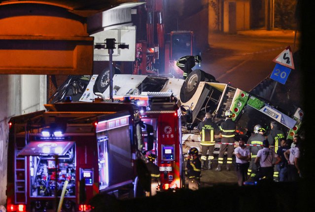 Firefighters and rescue personnel work near a coach after it crashed off an overpass near Venice, in Mestre, Italy on October 4, 2023. (Photo by Claudia Greco/Reuters)