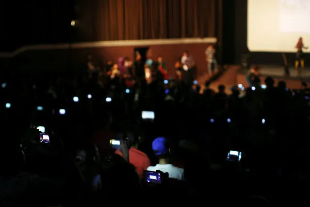 People use cell phones and tablets at a cinema where the Cuban Otaku festival is taking place in Havana, Cuba, July 24, 2016. (Photo by Alexandre Meneghini/Reuters)
