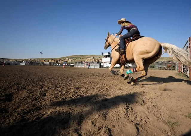 Taylor Giles, of Rockyview County, Alberta races out of the gate in ladies barrel racing during the first Writing-On-Stone Rodeo held since the coronavirus disease (COVID-19) pandemic in the World Heritage Site location of Writing-On-Stone Provincial Park, Alberta, Canada on July 31, 2022. (Photo by Leah Hennel/Reuters)