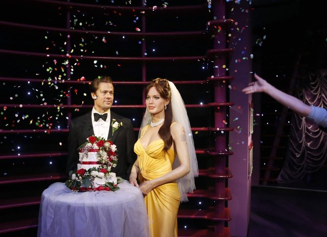 Wax models of actors Brad Pitt and Angelina Jolie have confetti thrown on them after being presented with a wedding cake and a bridal veil to celebrate their recent wedding, at the Madame Tussauds attraction in Sydney, August 29, 2014. Angelina Jolie and Brad Pitt, Hollywood's first couple, married in France over the weekend following a two-year engagement, ending nearly a decade of fevered tabloid speculation over whether “Brangelina” would ever tie the knot. (Photo by Jason Reed/Reuters)