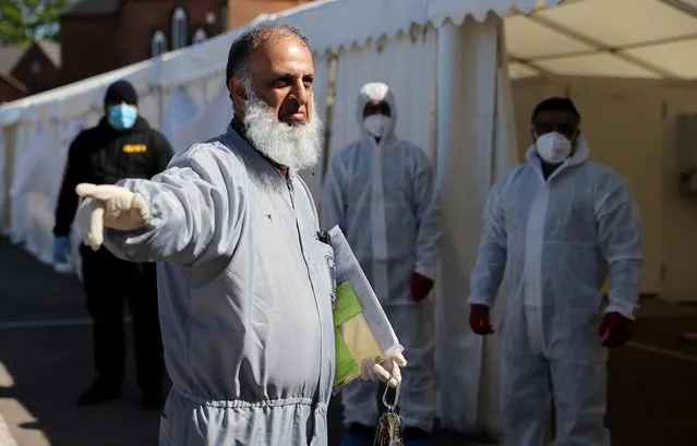 Workers wearing protective equipment are seen on the grounds of the Central Jamia Mosque Ghamkol Sharif, a temporary morgue set up at a Mosque as the spread of the coronavirus disease (COVID-19) continues, Birmingham, Britain, April 21, 2020. (Photo by Carl Recine/Reuters)