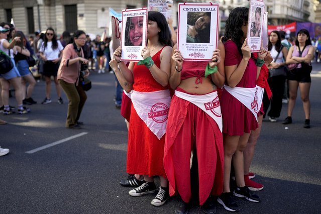 Protesters hold photos of human trafficking victims during a demonstration marking International Day for the Elimination of Violence against Women, in Buenos Aires, Argentina, Saturday, November 25, 2023. (Phoot by Natacha Pisarenko/AP Photo)