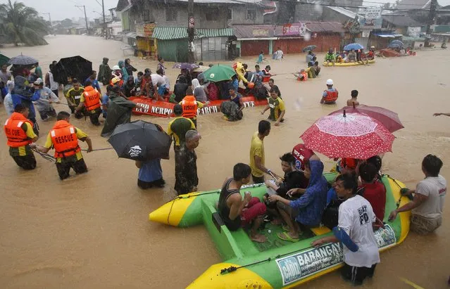 Flood victims are evacuated in rescue boats after their homes were swamped by heavy flooding in Marikina, Metro Manila September 19, 2014. (Photo by Erik De Castro/Reuters)