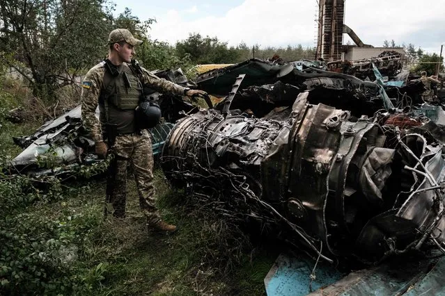 A Ukrainian army's press officer shows the debris of Russian air strike aircraft Su-34 at a collection point of destroyed Russian armoured vehicles at an animal feed plant in the recently retaken town of Lyman in Donetsk region, on October 5, 2022, amid the Russian invasion of Ukraine. (Photo by Yasuyoshi Chiba/AFP Photo)