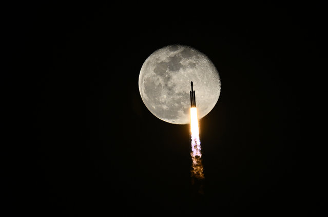 Falcon Heavy rocket flies past a near full moon as it launches the X37B at 8:07 PM for the United States Space Force from Launch Complex 39 at the Kennedy Space Center, Florida on Thursday, December 28, 2023. This is the seventh mission for the military space plane, but the first launched by SpaceX. (Photo by Joe Marino/UPI/Rex Features/Shutterstock)