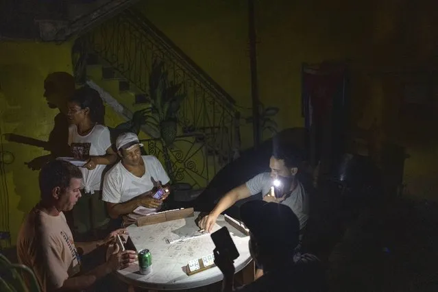 People play dominoes by flashlight during a blackout in Havana, Cuba, Wednesday, September 28, 2022. (Photo by Ramon Espinosa/AP Photo)